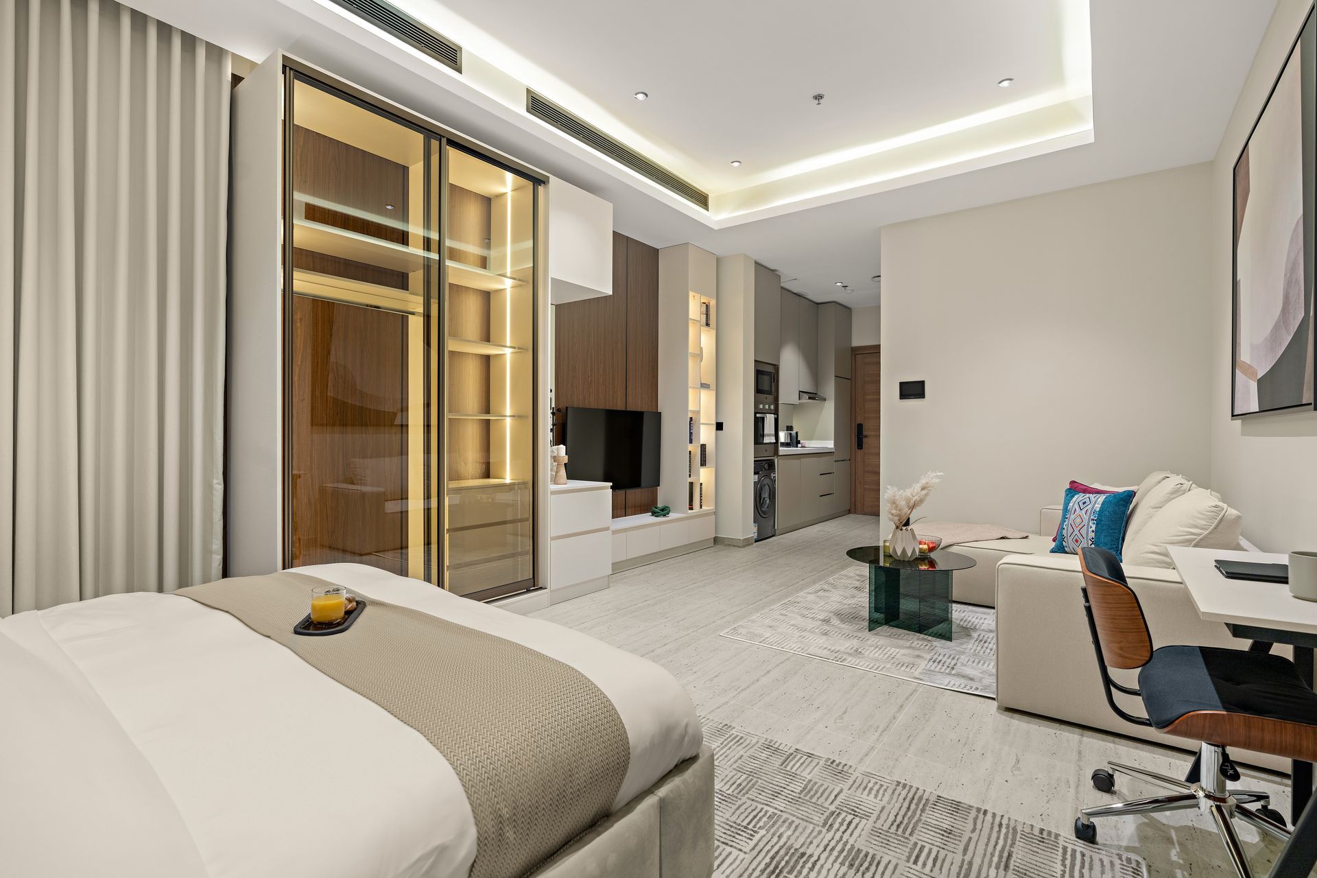 A bedroom with a bed , couch , desk and television.