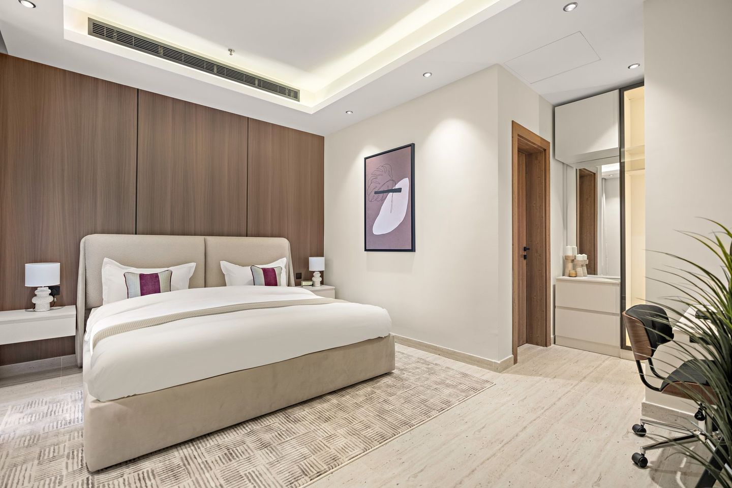 A bedroom with a large bed and a desk.