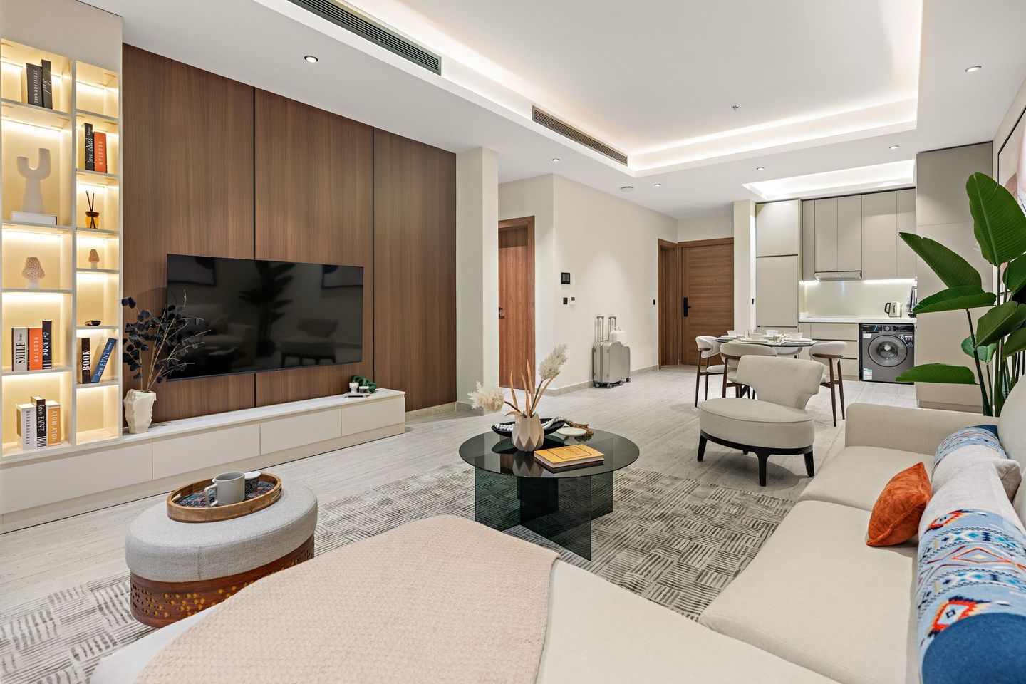 A living room with a couch , table , chairs and a flat screen tv.