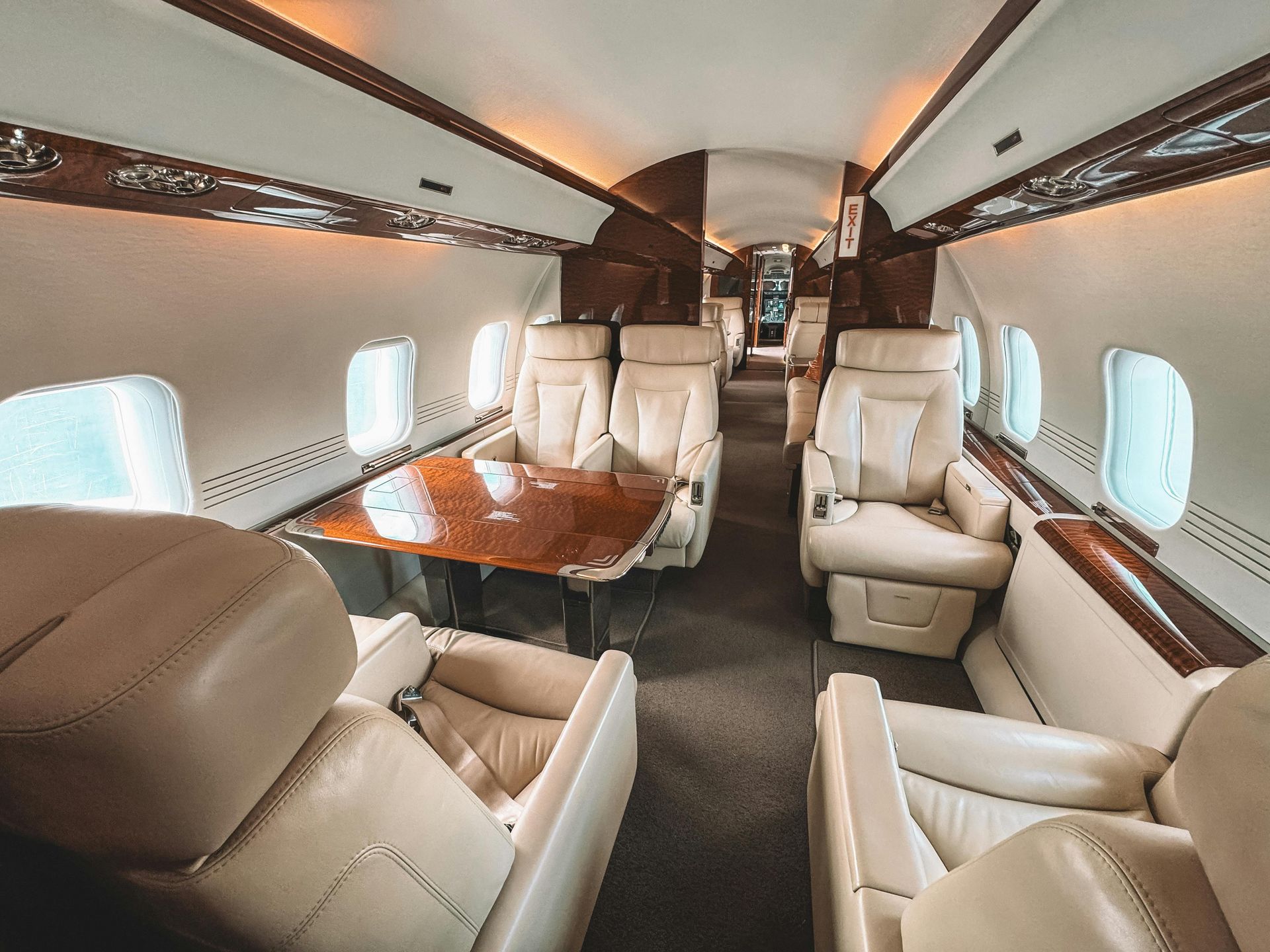 The inside of a private jet with a table and chairs. Aviation marketing