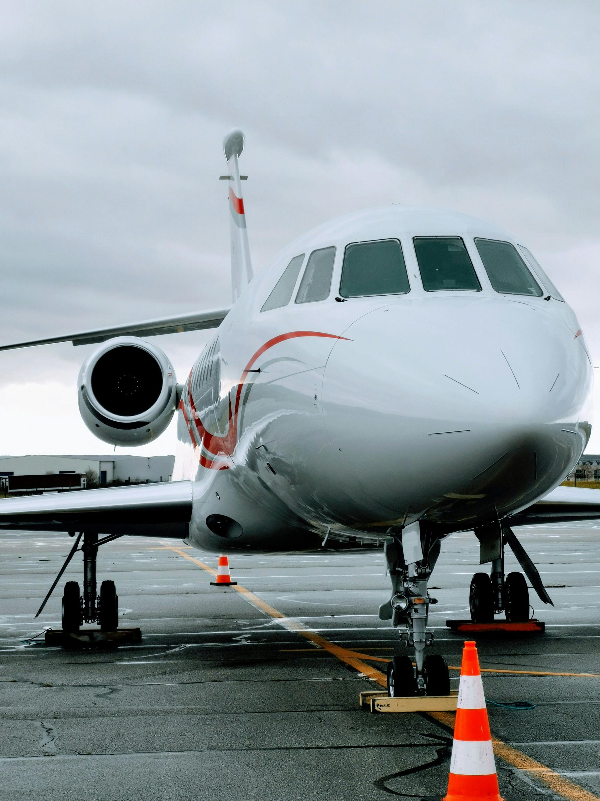 A white airplane is parked on a runway next to a traffic cone. Aviation charter SEO