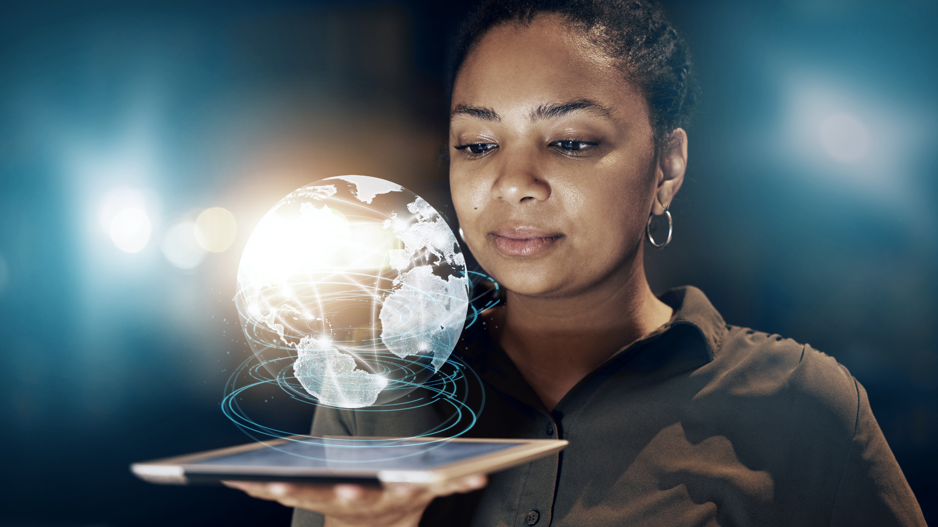 A woman is holding a tablet with a globe coming out of it, implying how businesses can unlock the full potential of AI and cybersecurity.