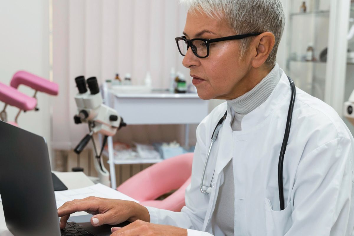 A female doctor is using a laptop computer in a gynecological office.