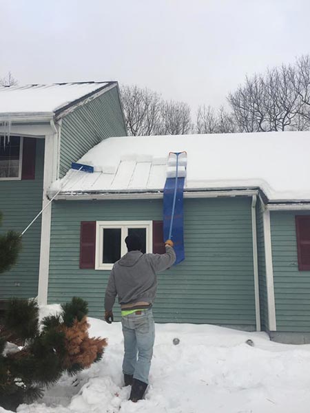Removing snow in his house roof — Power Washing Services in New Galilee, PA