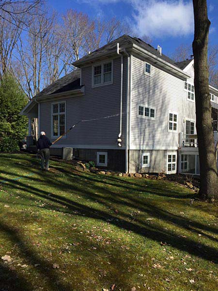 Old man cleaning the side of his house — Power Washing Services in New Galilee, PA