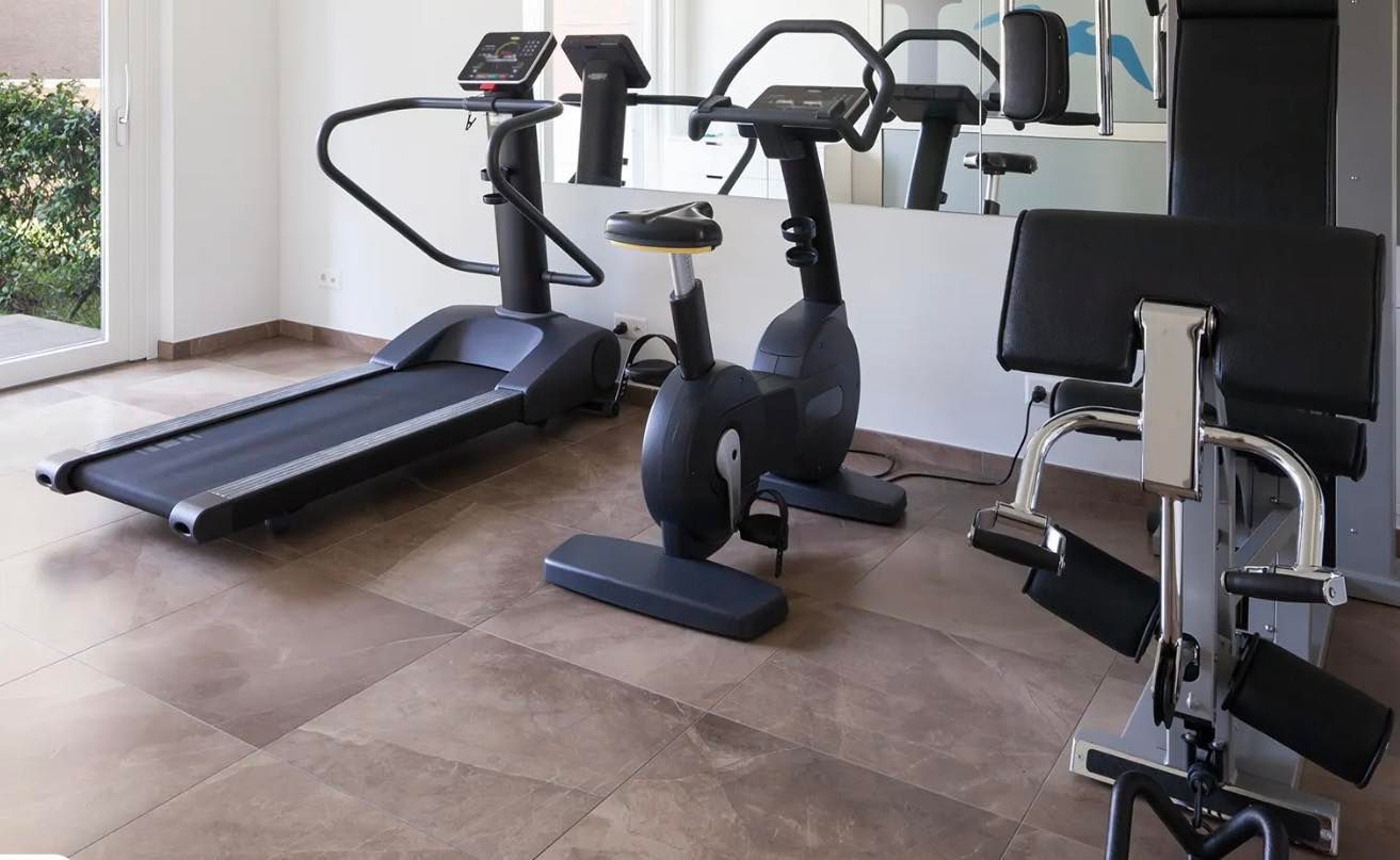 A gym with a treadmill and a bike