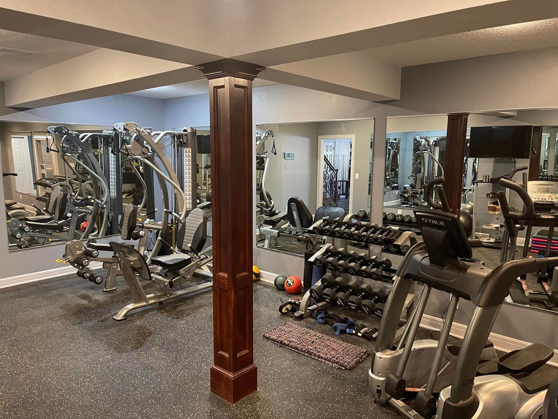 A gym filled with lots of exercise equipment and a large mirror.