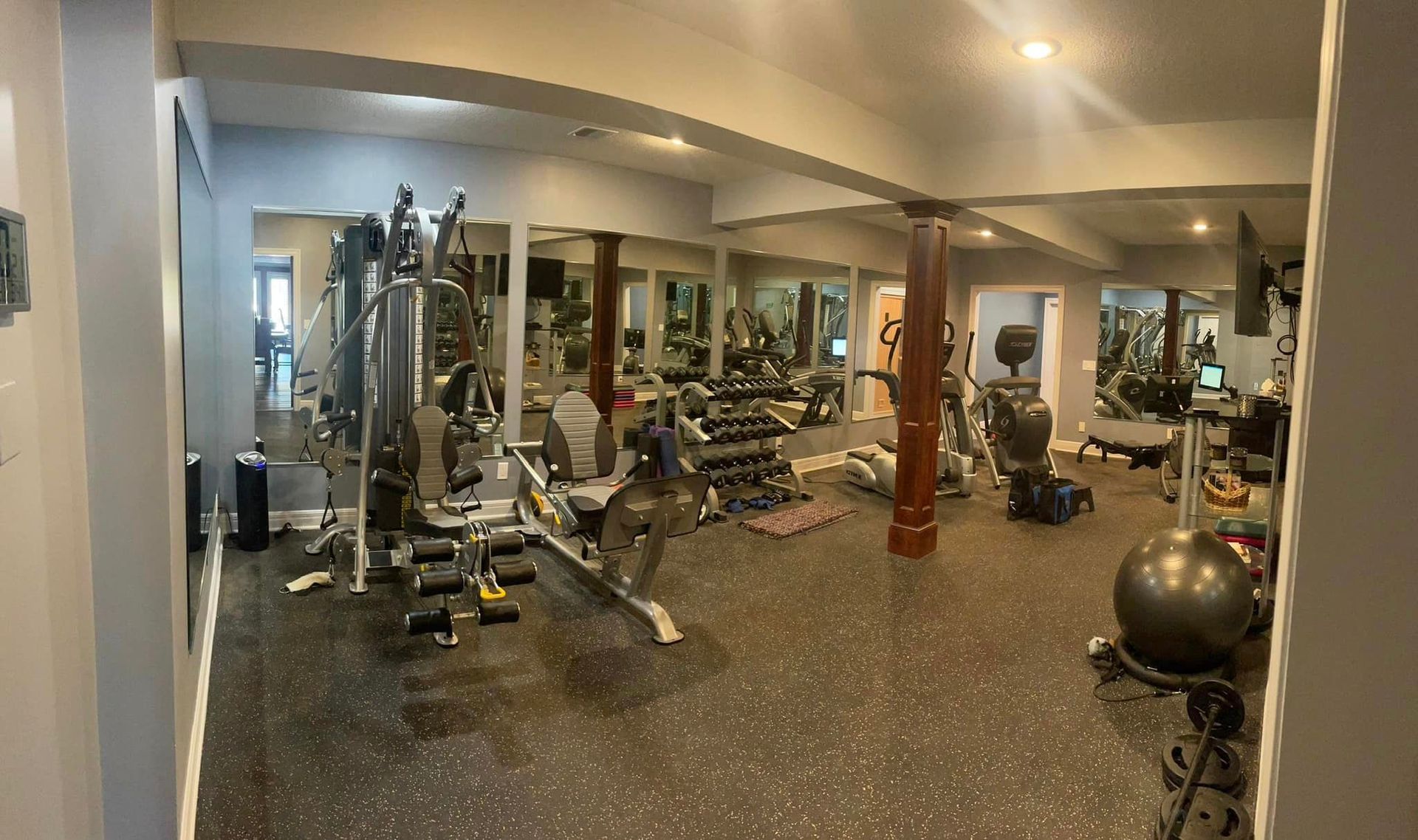 A large gym with a lot of equipment and mirrors