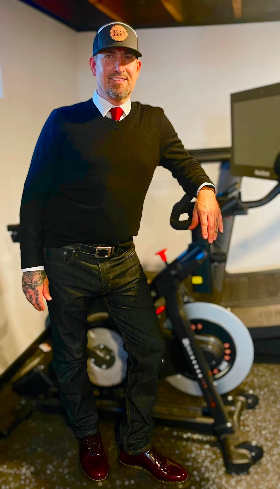 A man standing next to a spinning bike in a gym