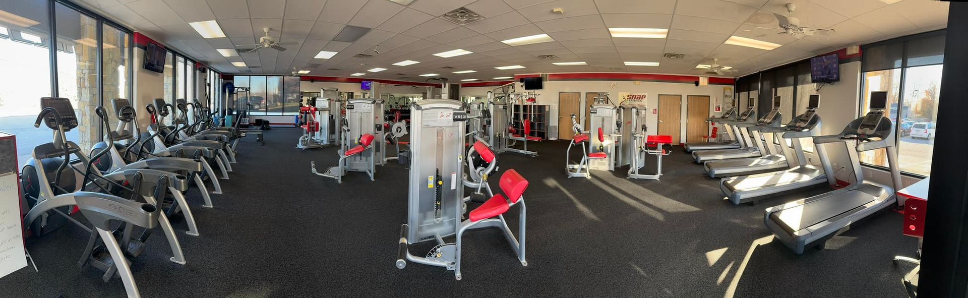 A large gym filled with lots of exercise equipment.