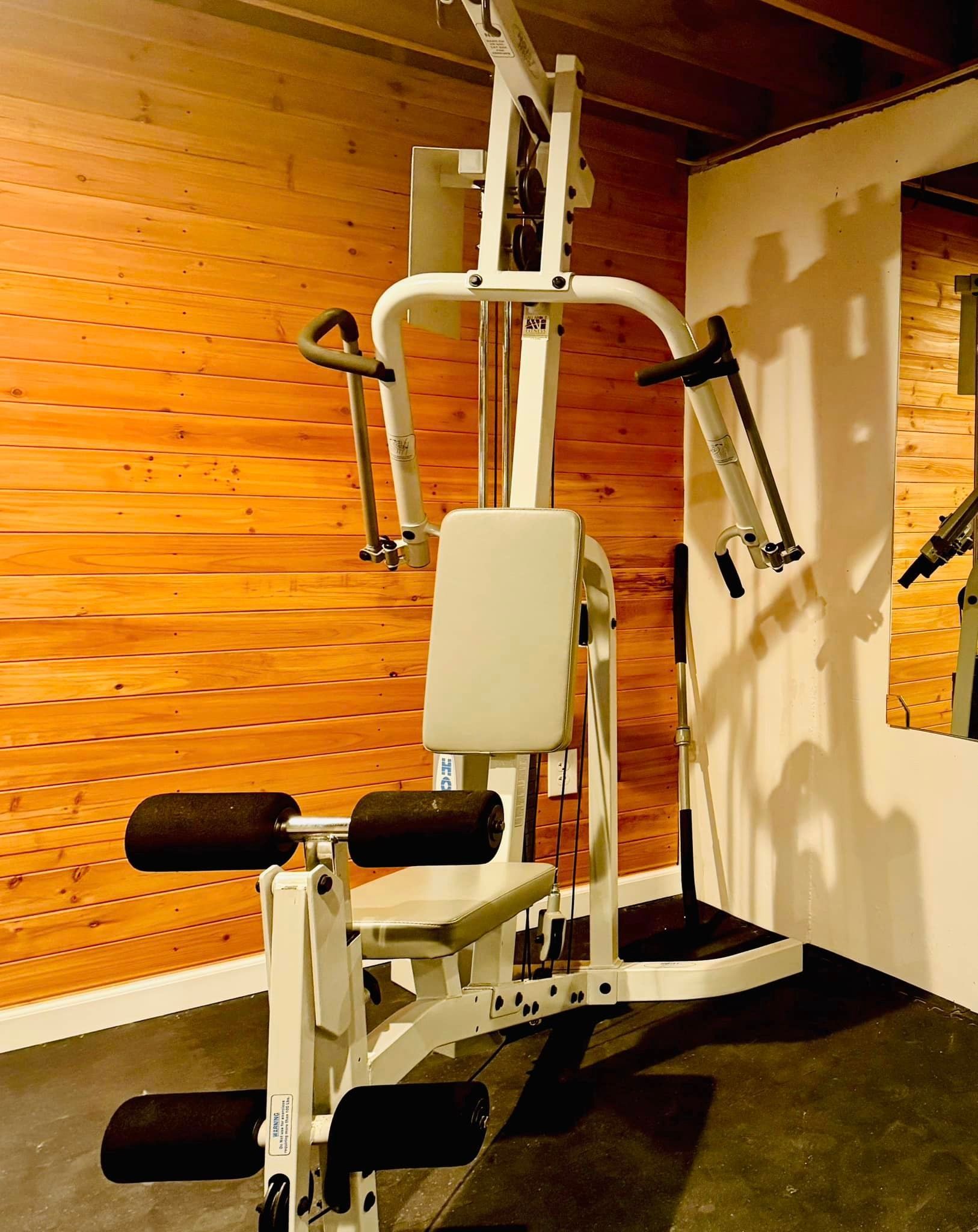 A gym machine is sitting in a room with a wooden wall.