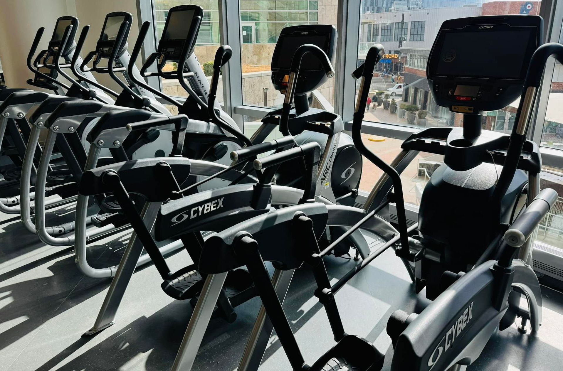 A row of exercise bikes are lined up in a gym.