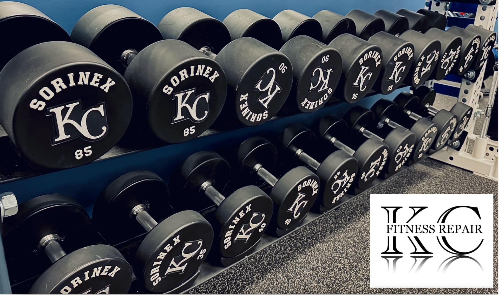 A row of black dumbbells with the letters kc on them