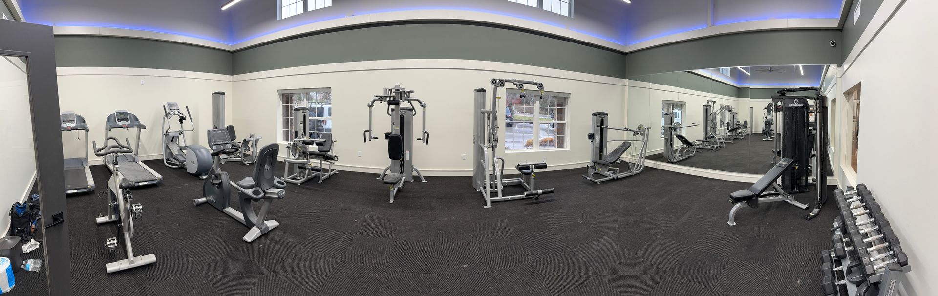 A panoramic view of a gym filled with lots of exercise equipment.