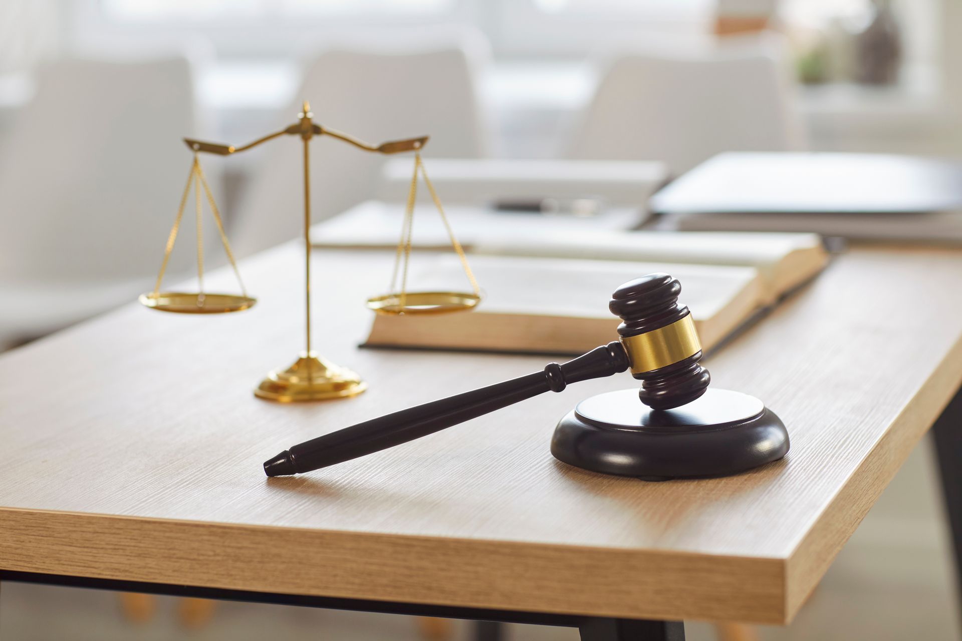 Gavel and justice scales on a desk in a law office during a criminal defense consultation.