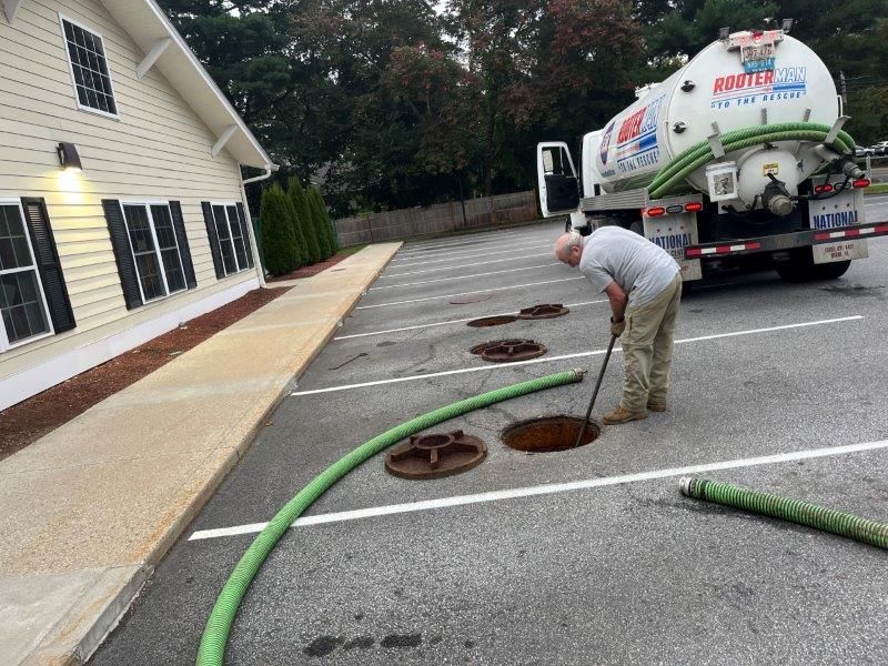 Chrome plumbing trap under a white sink in a tiled bathroom.