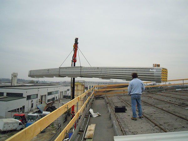 un uomo in un cantiere edile guarda una gru che solleva materiali