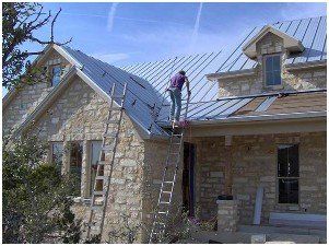 operaio lavora al tetto di una villetta su di una scala