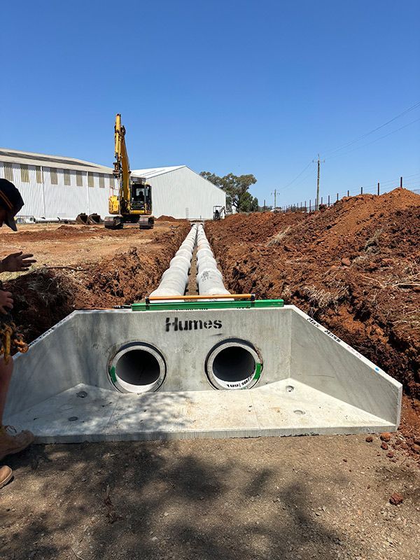 A Construction Site With A Yellow Excavator In The Background — BJB Plumbing & Gasfitting in Dubbo, NSW