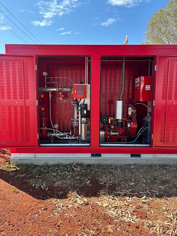 A Red Box with The Doors Open Is Sitting on Top of A Dirt Field — BJB Plumbing & Gasfitting in Coonabarabran, NSW