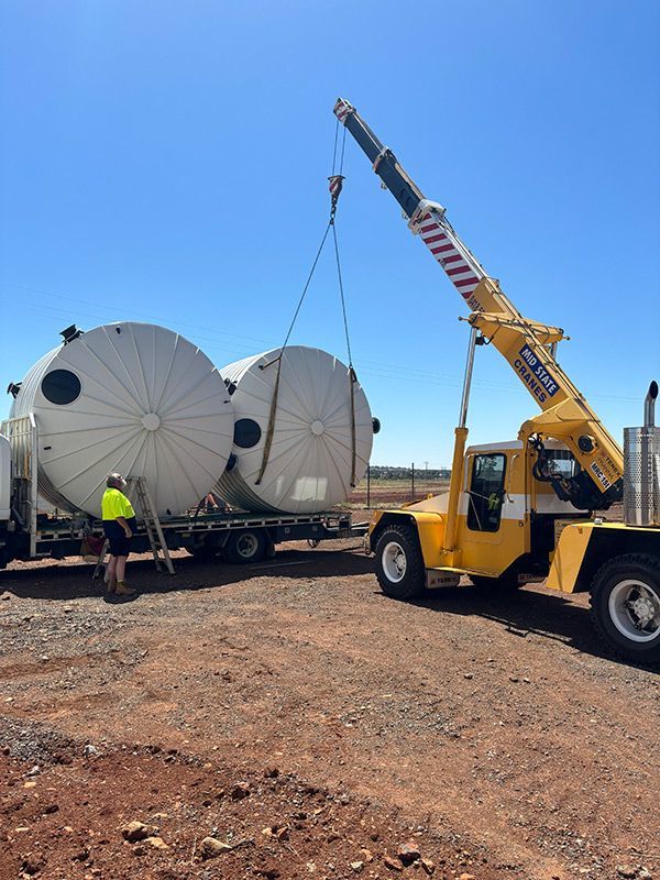 A Crane Is Lifting a Large White Tank from A Truck — BJB Plumbing & Gasfitting in Dubbo, NSW