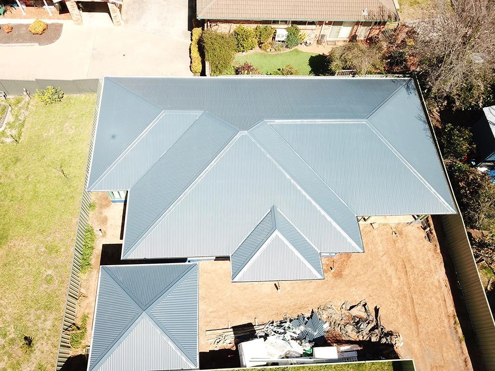 An View Of A House With A Blue Roof — BJB Plumbing & Gasfitting in Dubbo, NSW