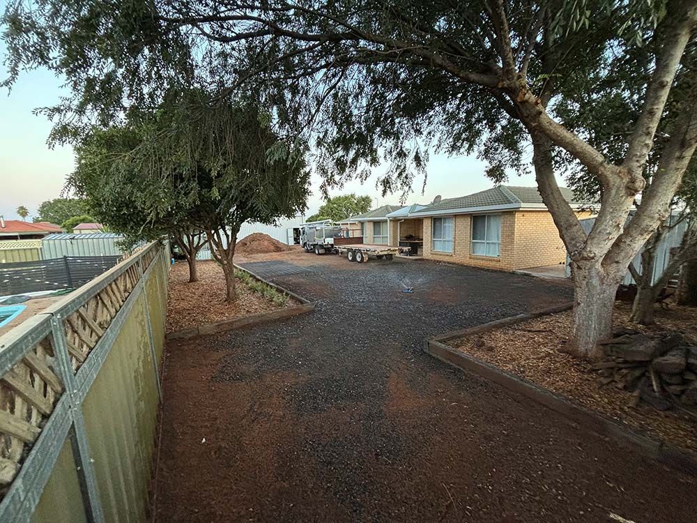 A Driveway Leading to A House with A Fence and Trees — BJB Plumbing & Gasfitting in Cobar, NSW