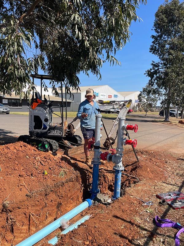 Two Black Tanks Are Sitting in A Hole in The Ground — BJB Plumbing & Gasfitting in Parkes, NSW
