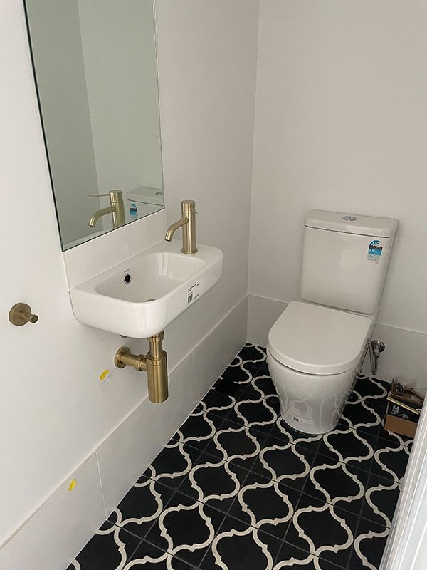 A Bathroom with A Toilet, Sink, and Mirror — BJB Plumbing & Gasfitting in Parkes, NSW