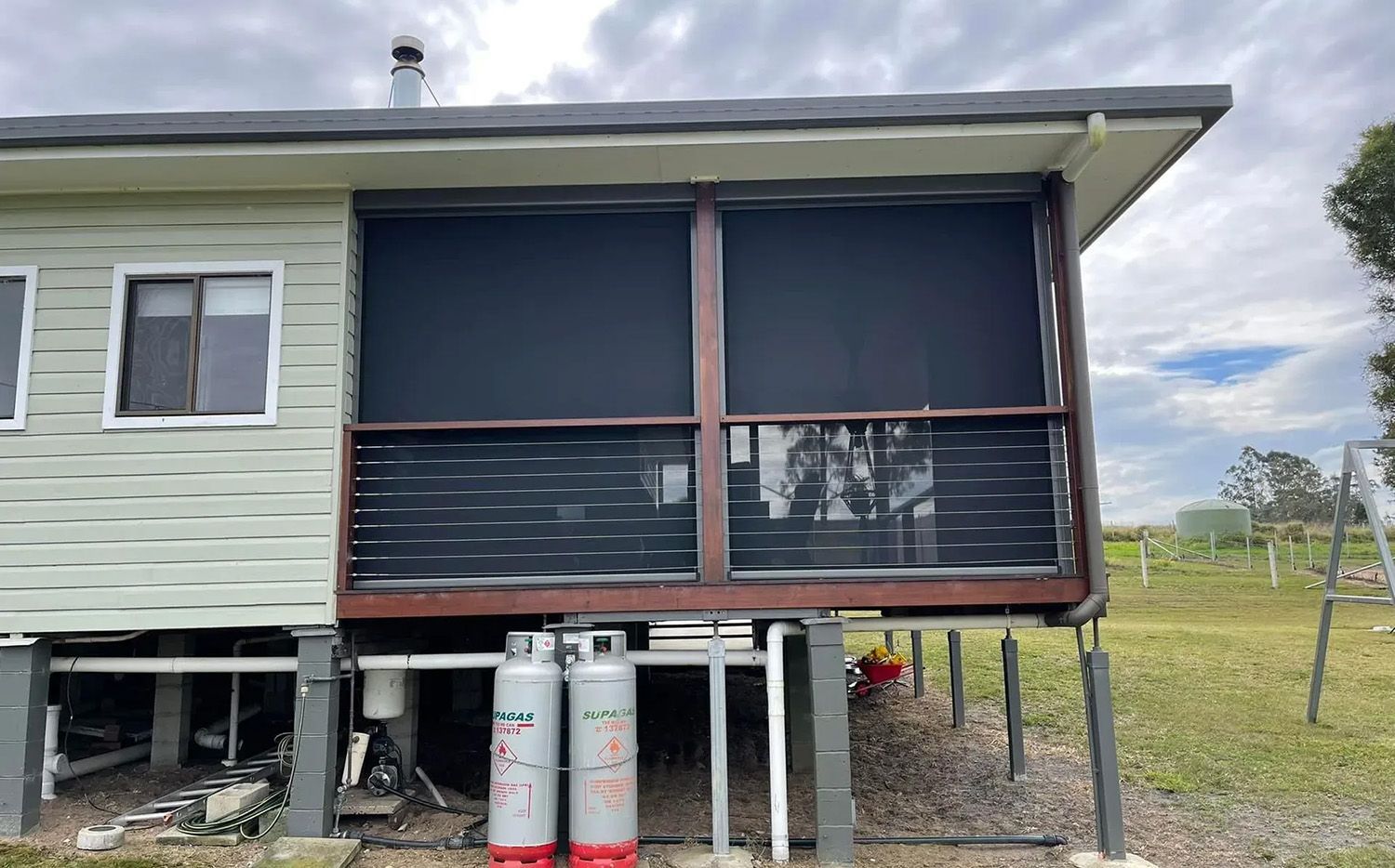 House With Black Roller Blinds On The Verandah