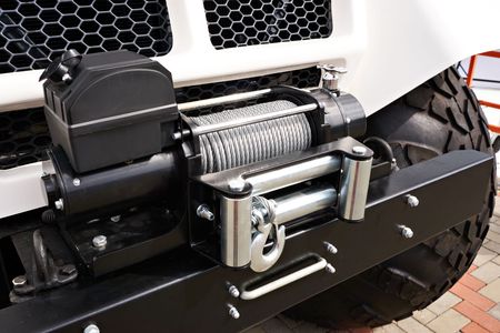 A close up of a winch on the front of a jeep