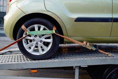 A car is being towed by a tow truck.