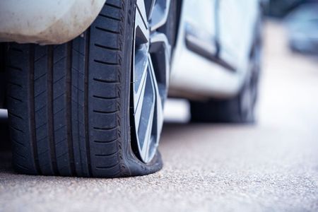 A close up of a flat tire on a car.