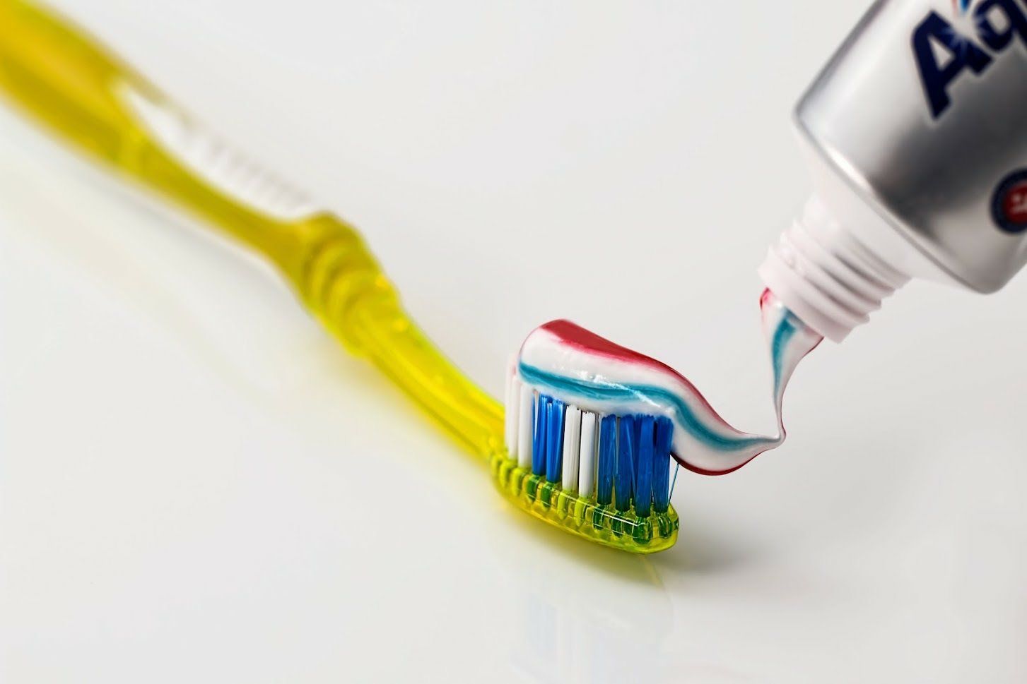 Putting Toothpaste On Toothbrush— Venice, FL — Davis & Beyer DDS PA