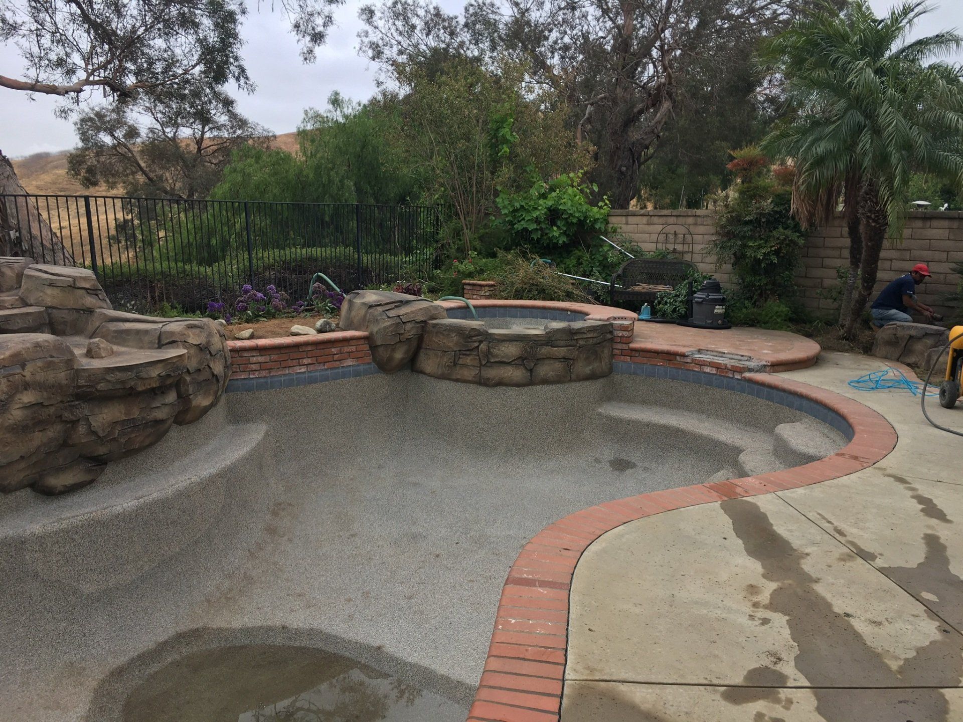 A large swimming pool with a hot tub in the middle of it.