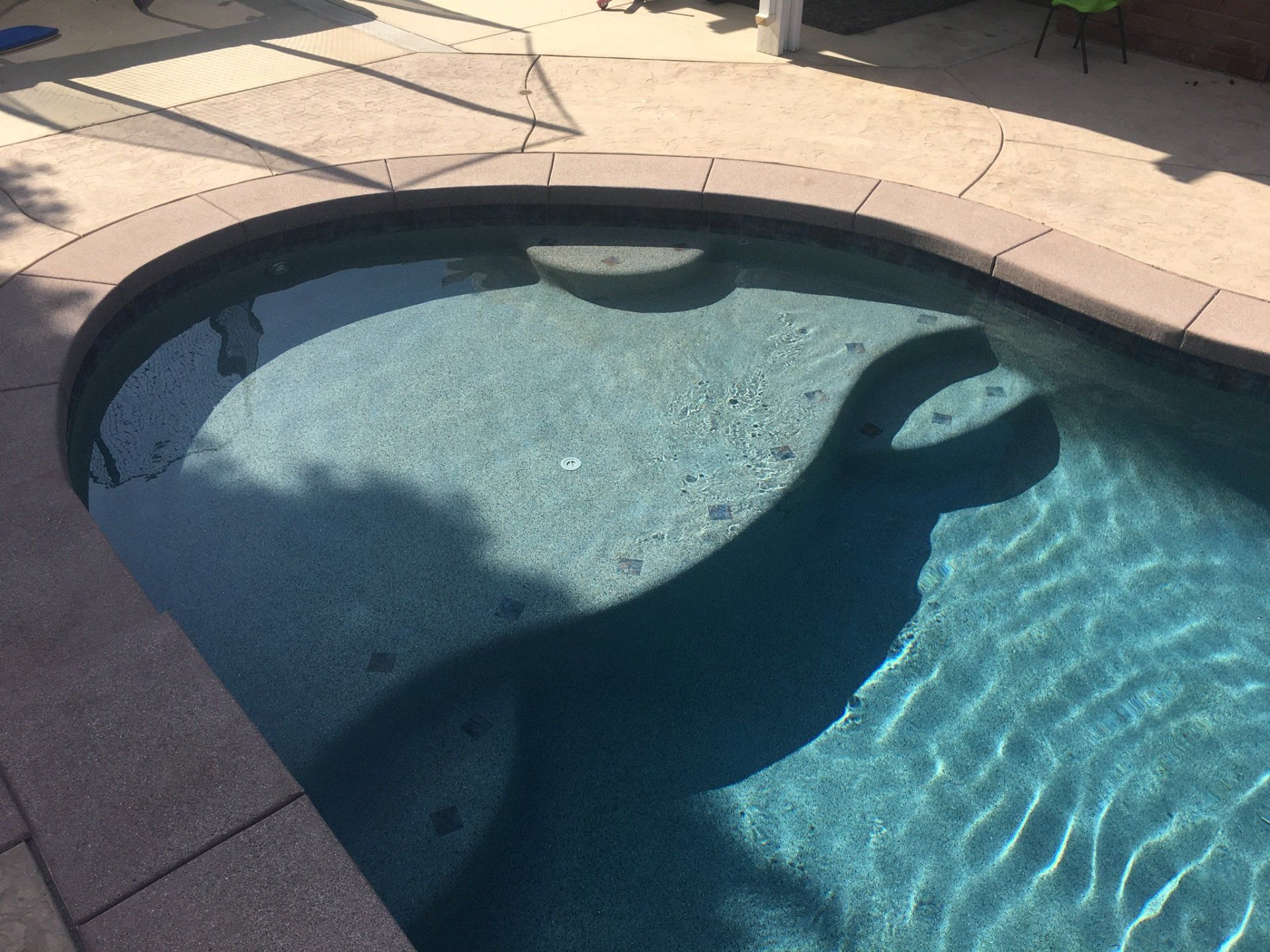 A swimming pool with a shadow of a person in the water