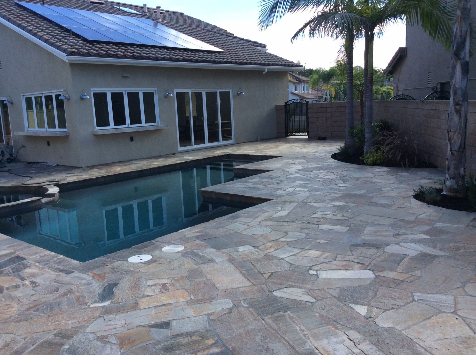 A house with a swimming pool and solar panels on the roof