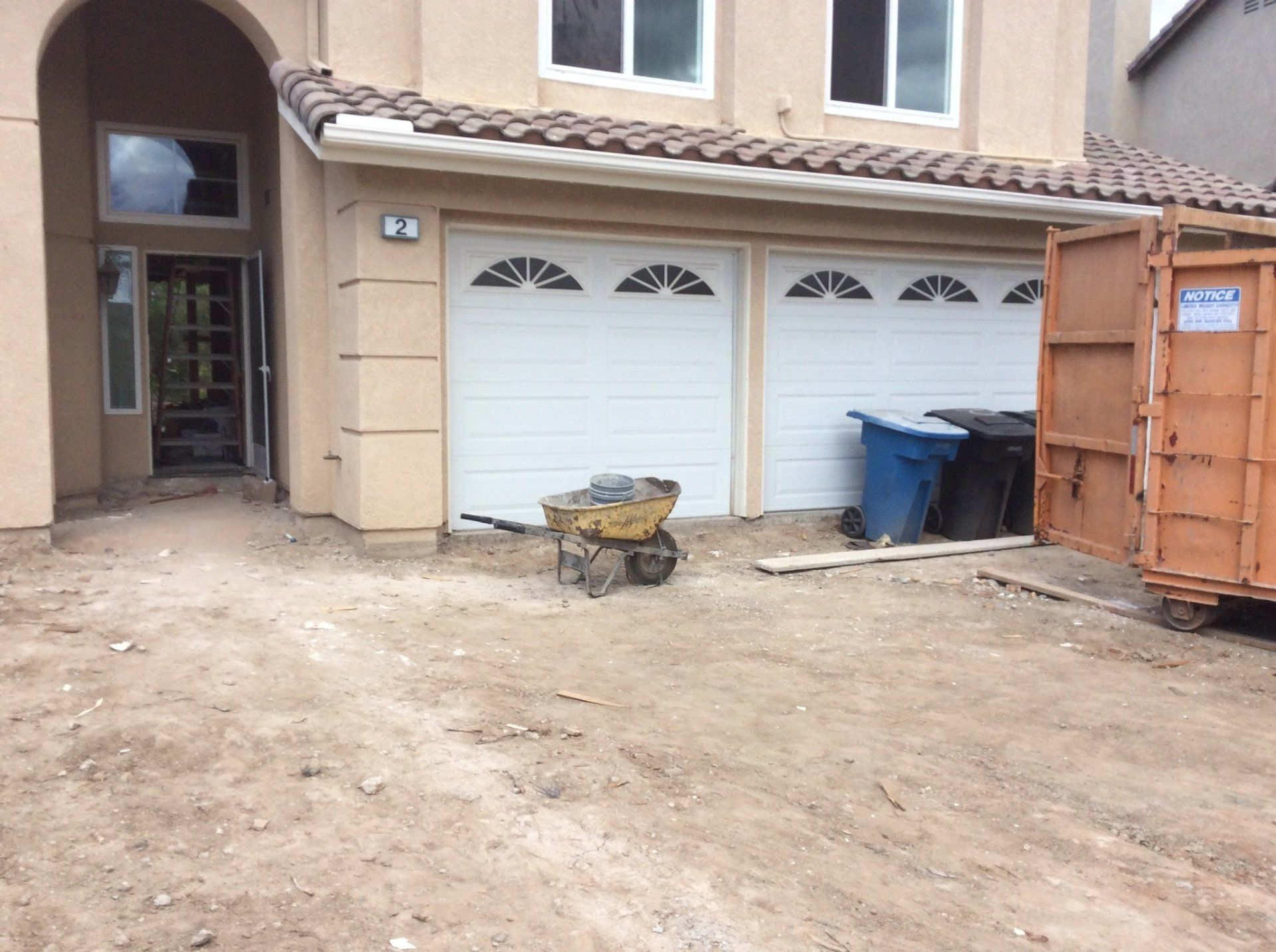 A wheelbarrow is parked in front of a house.