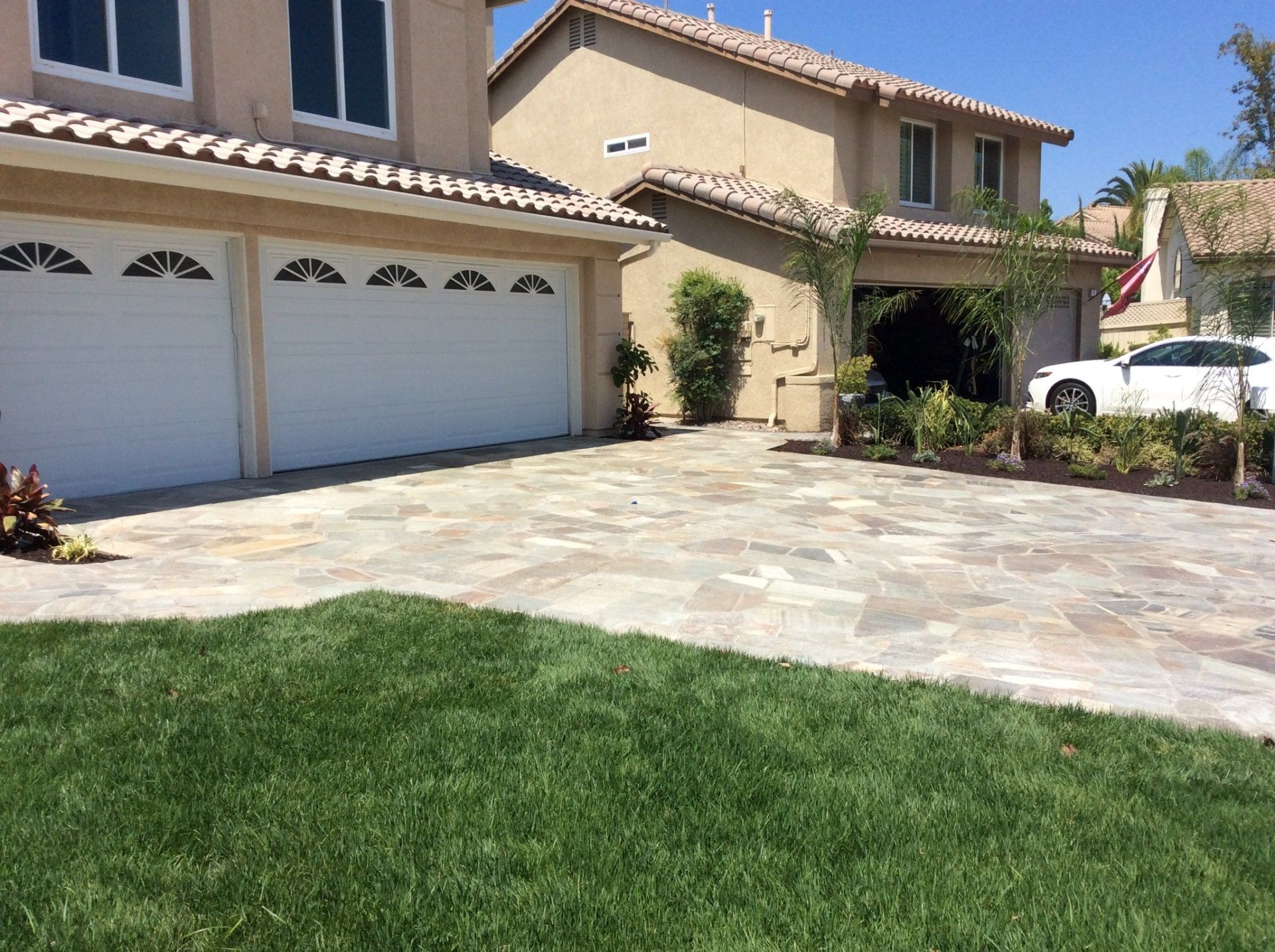 A large house with a white car parked in front of it.