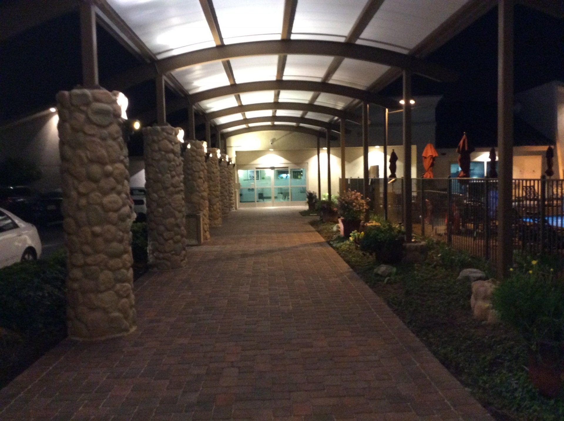 A brick walkway leading to a building at night