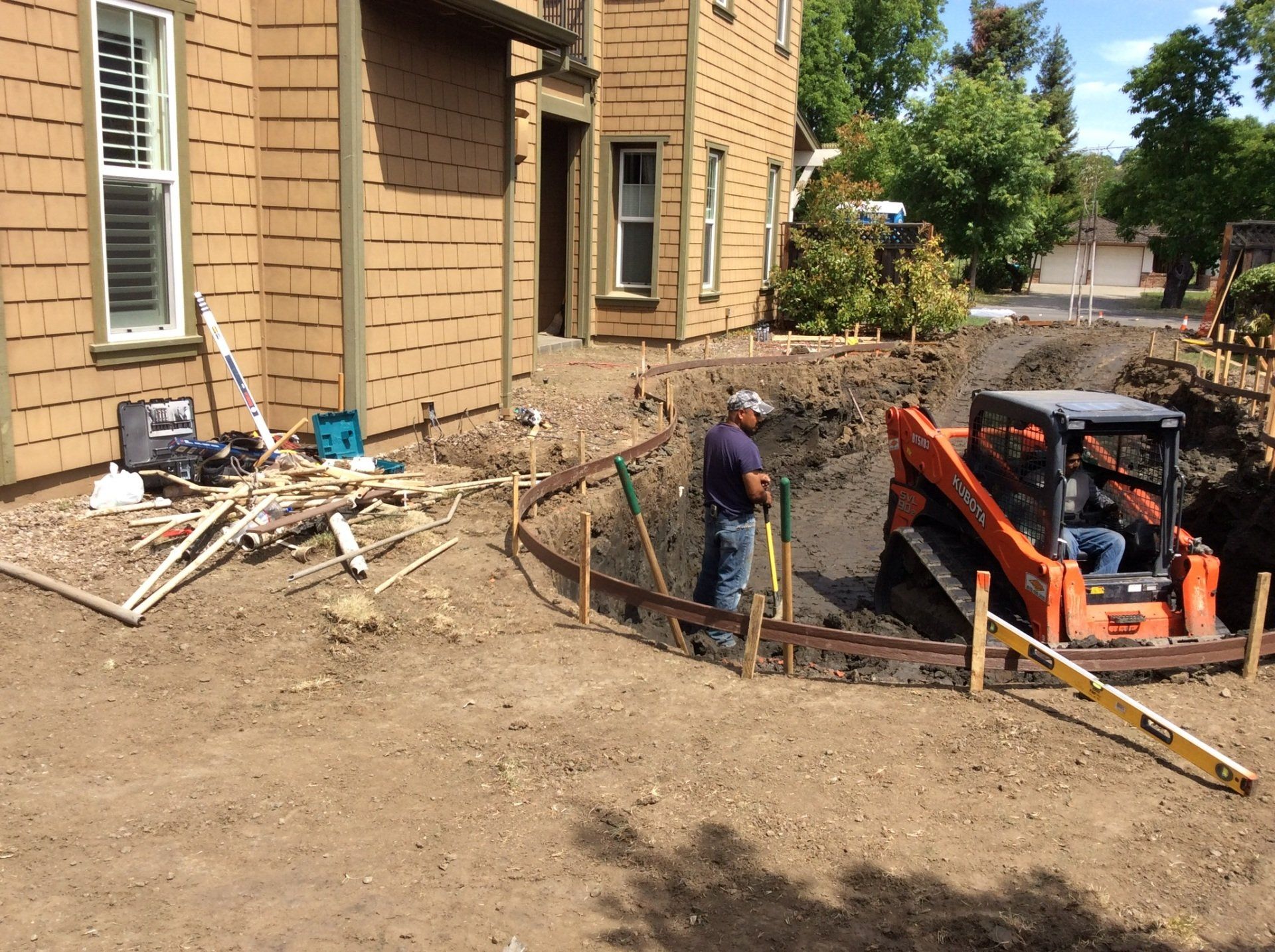 A man standing next to a bulldozer in front of a house