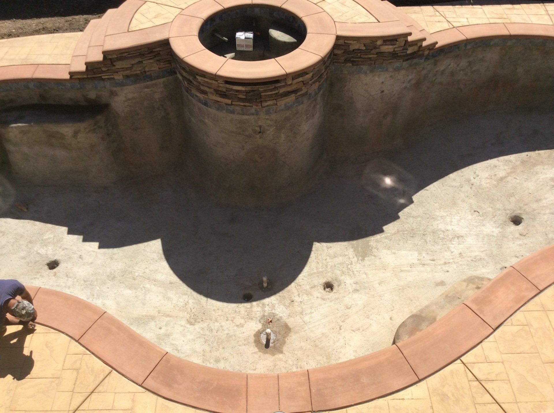 An aerial view of a swimming pool with a man working on it