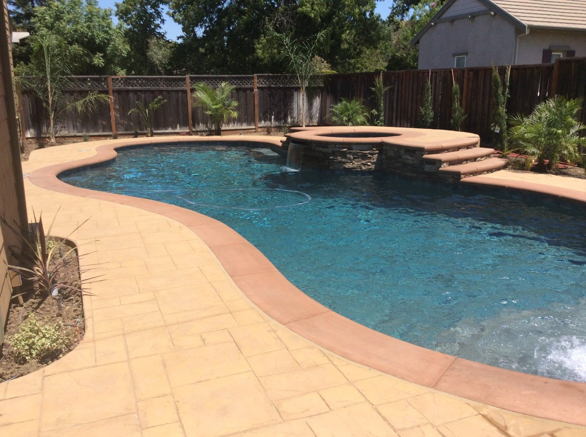 A large swimming pool with a waterfall in the middle and a Spa Spill Way