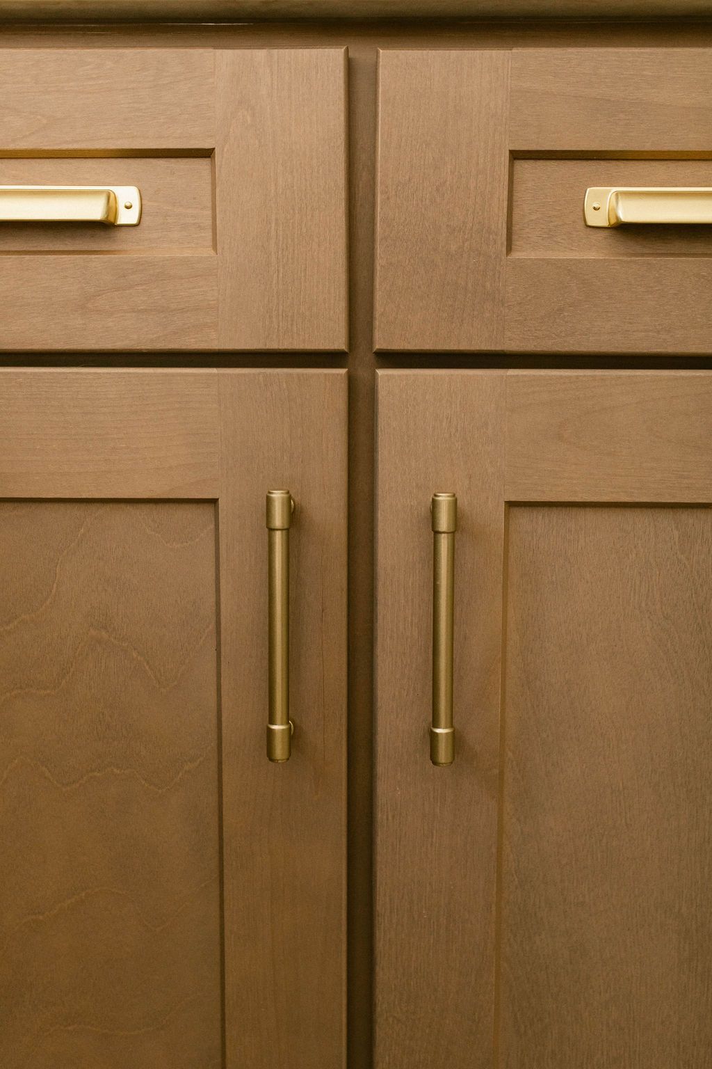 Close-up of brown wooden cabinets with brass handles.