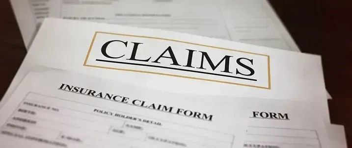 A stack of insurance claim forms with the word 