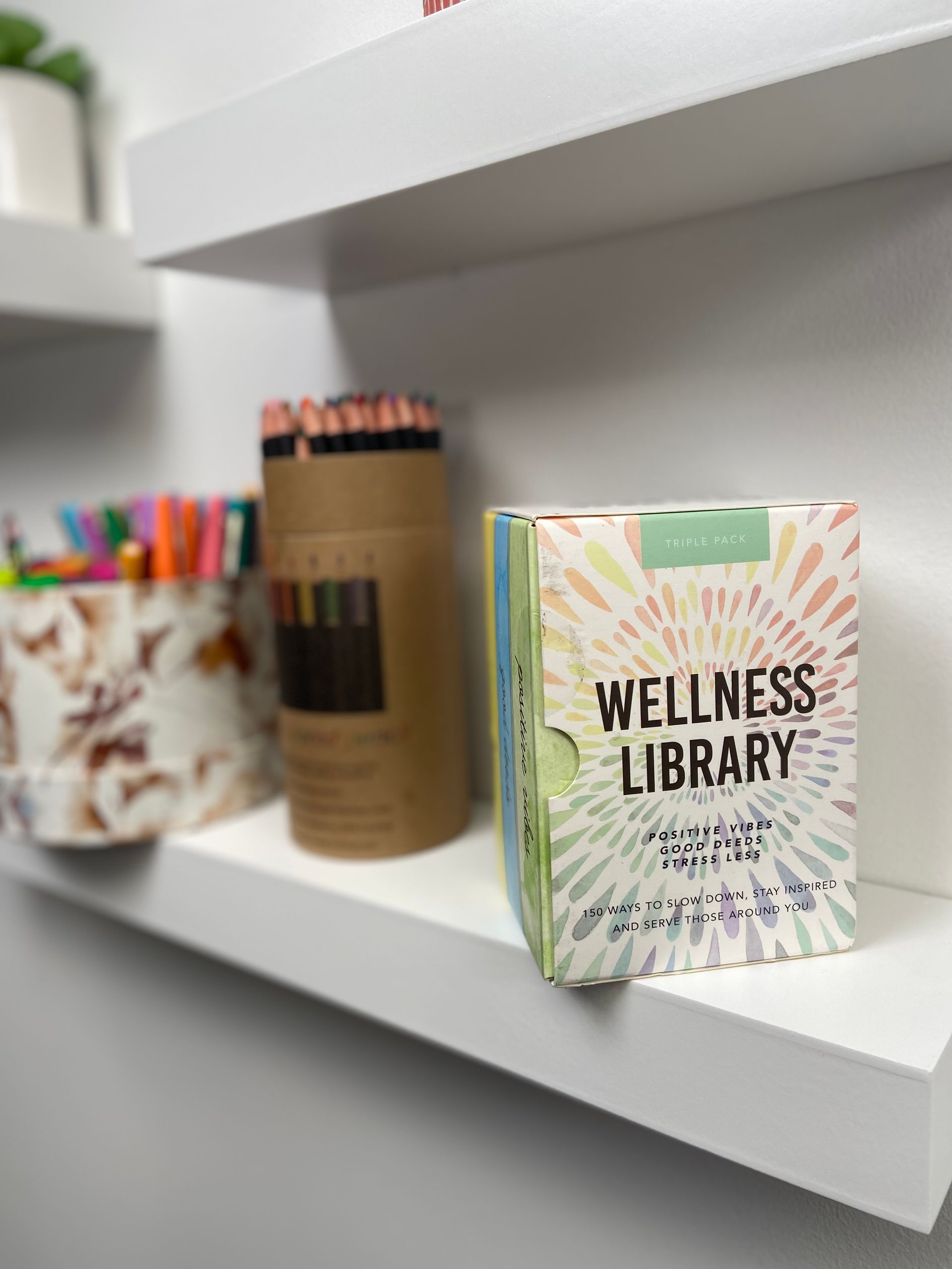 Craft materials sitting on a white shelf.