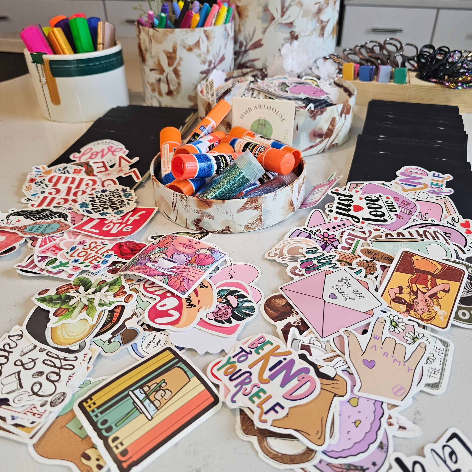 Various stickers and glue sticks spread out for a craft project.