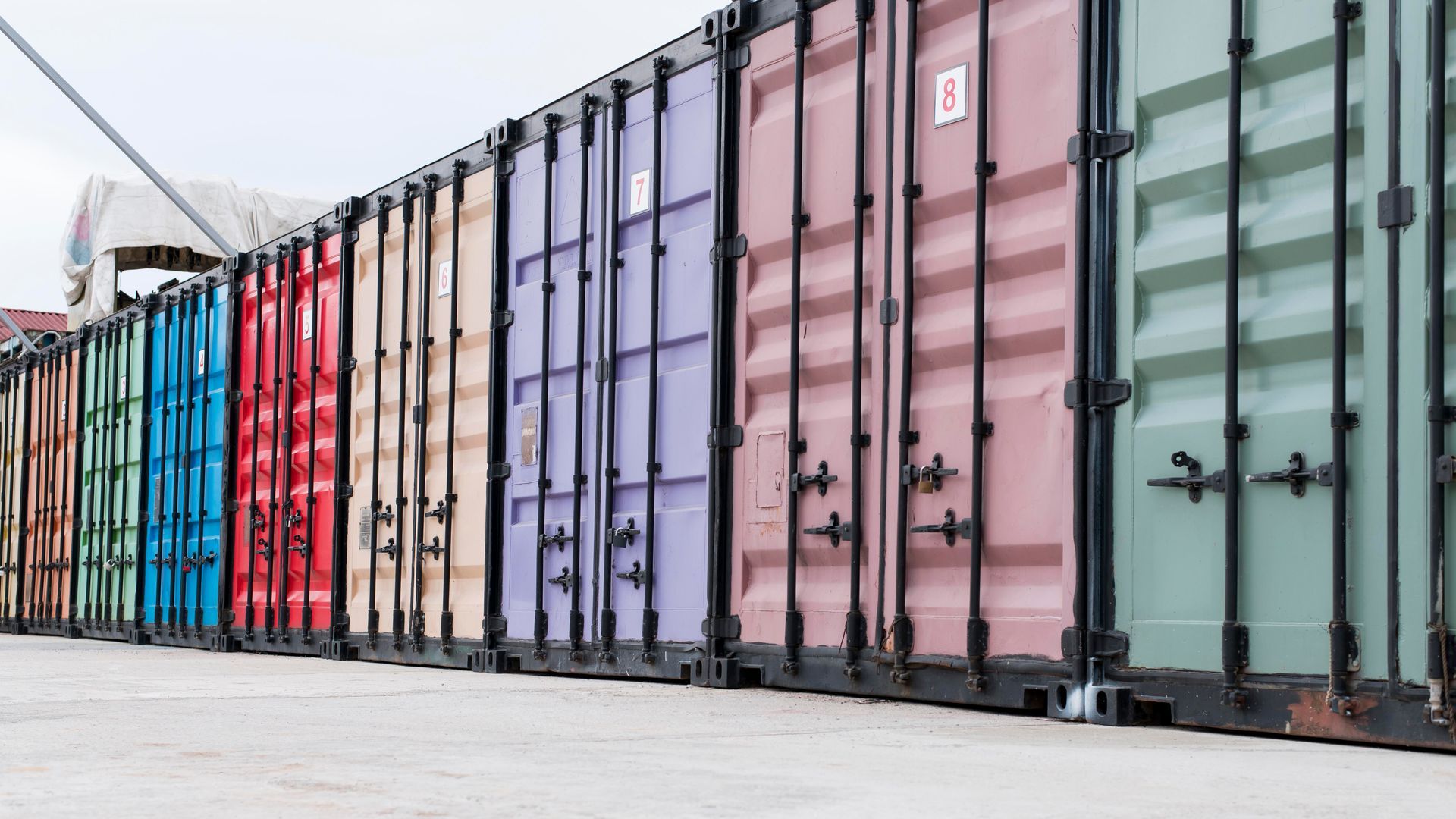 A row of colorful shipping containers are lined up in a row.