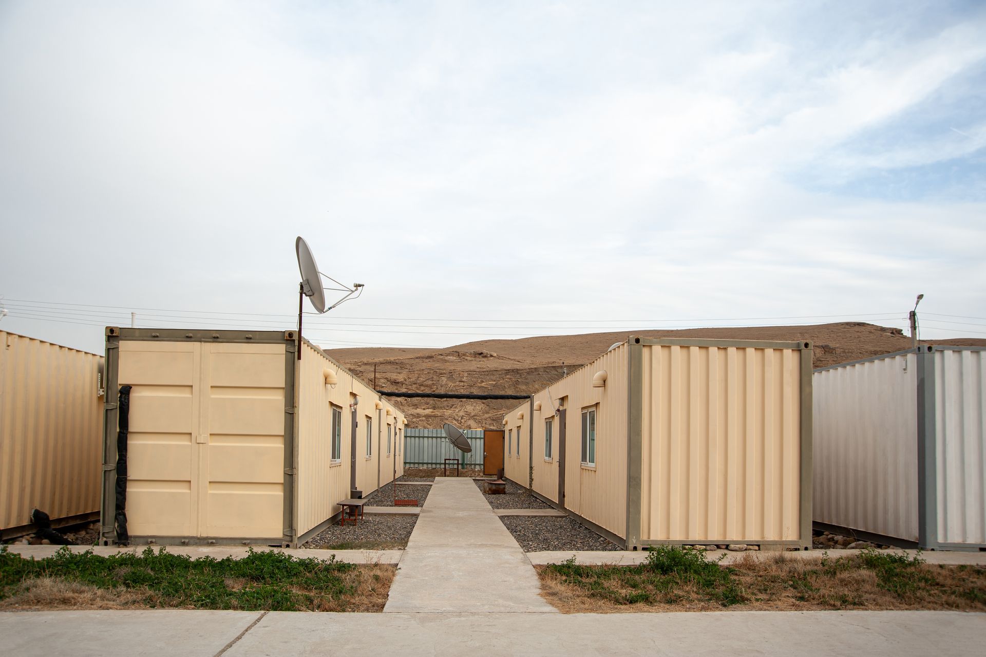 A row of shipping containers are lined up next to each other on a sidewalk.