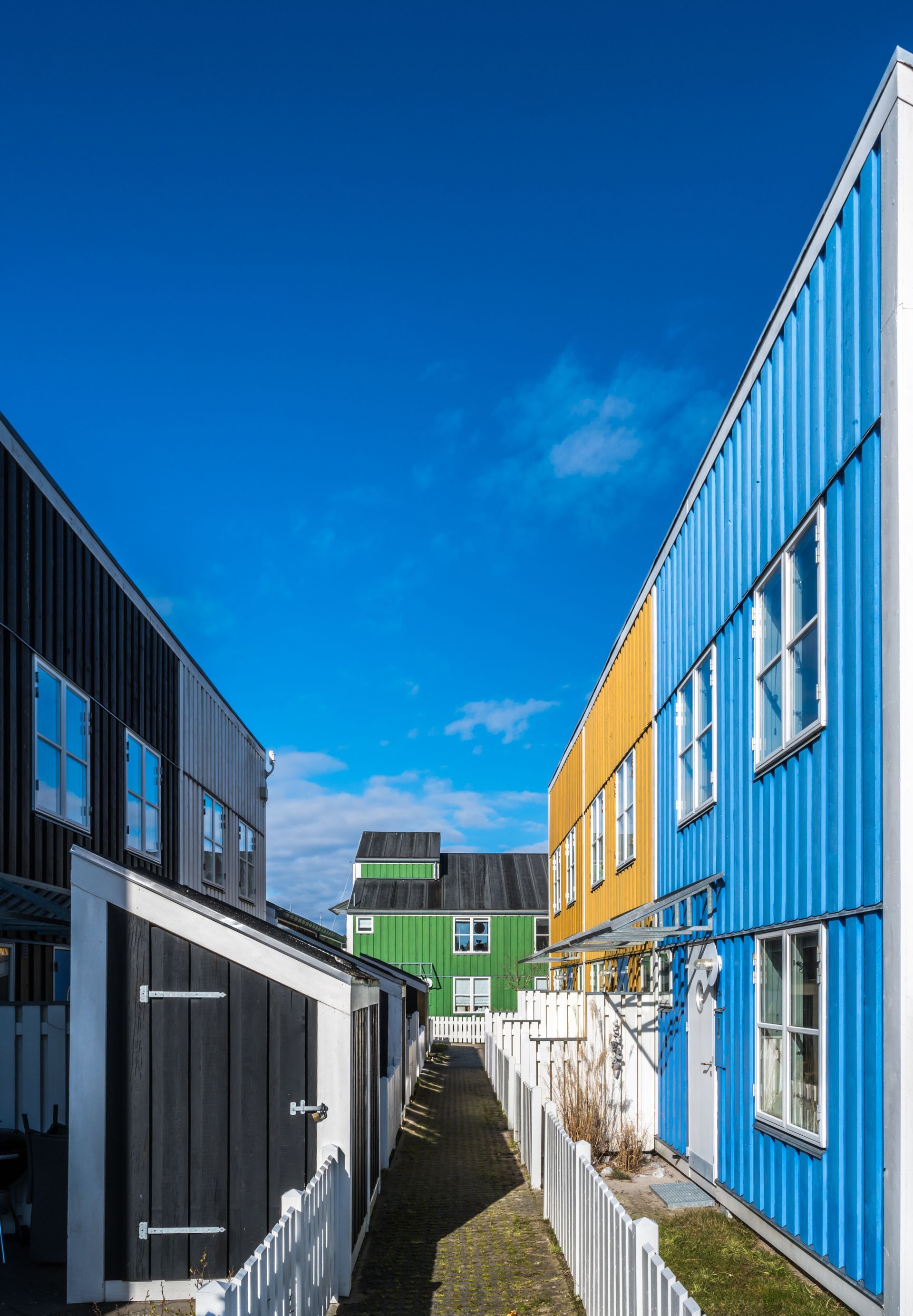 A row of colorful houses lined up next to each other on a sunny day.